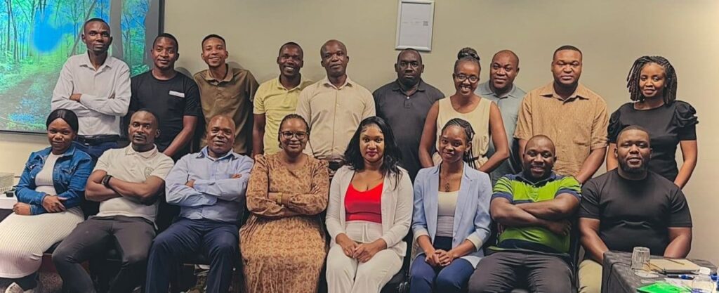 A group of 18 Zimbabwean men and women, sitting and standing and smiling for the camera